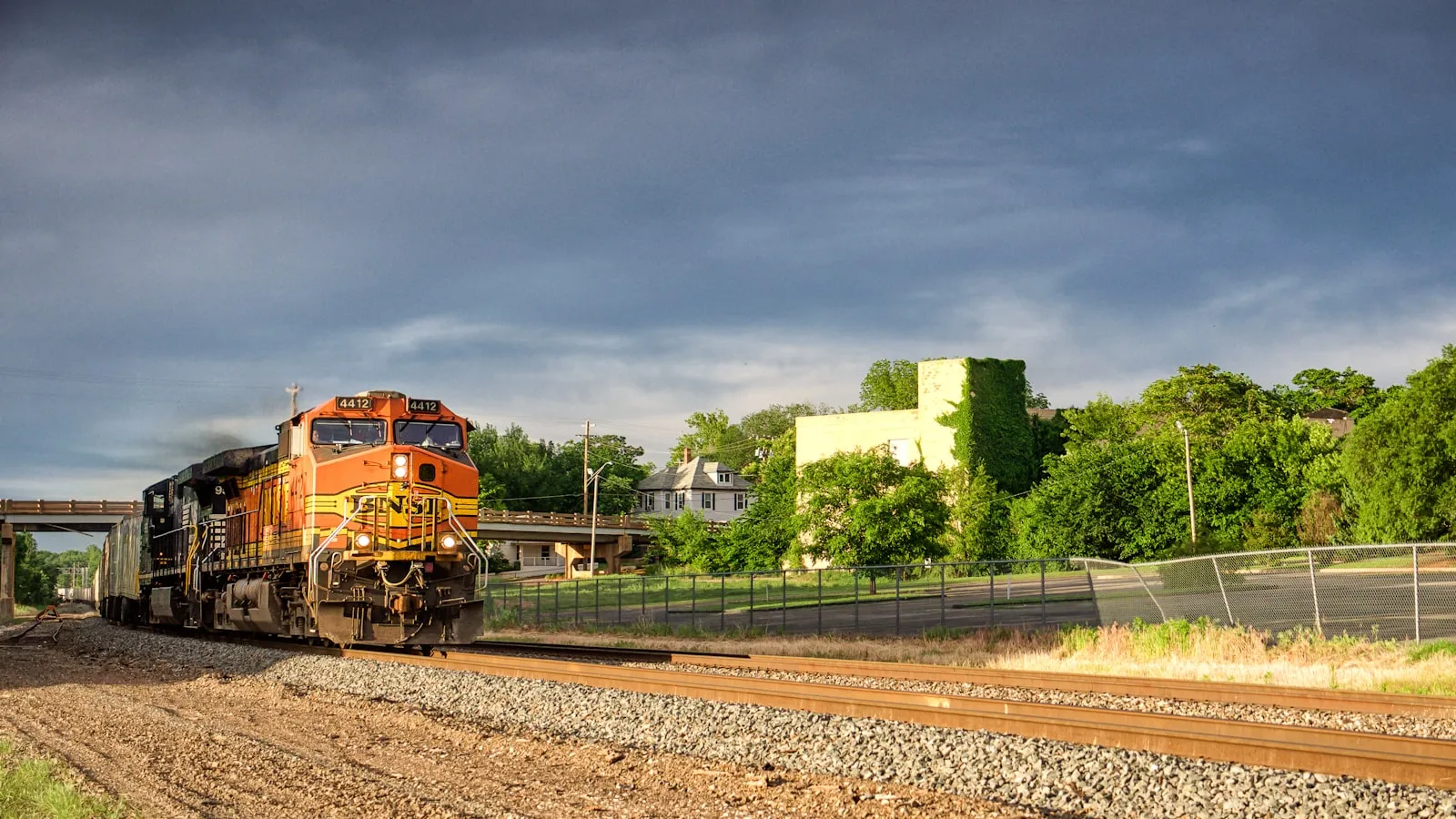 Bright orange train on the rails — colorful budget visual matching Vevor's price-vs-loudness positioning