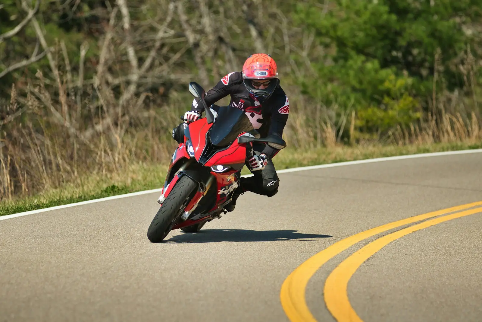 Motorcyclist leans into a curve on a winding road