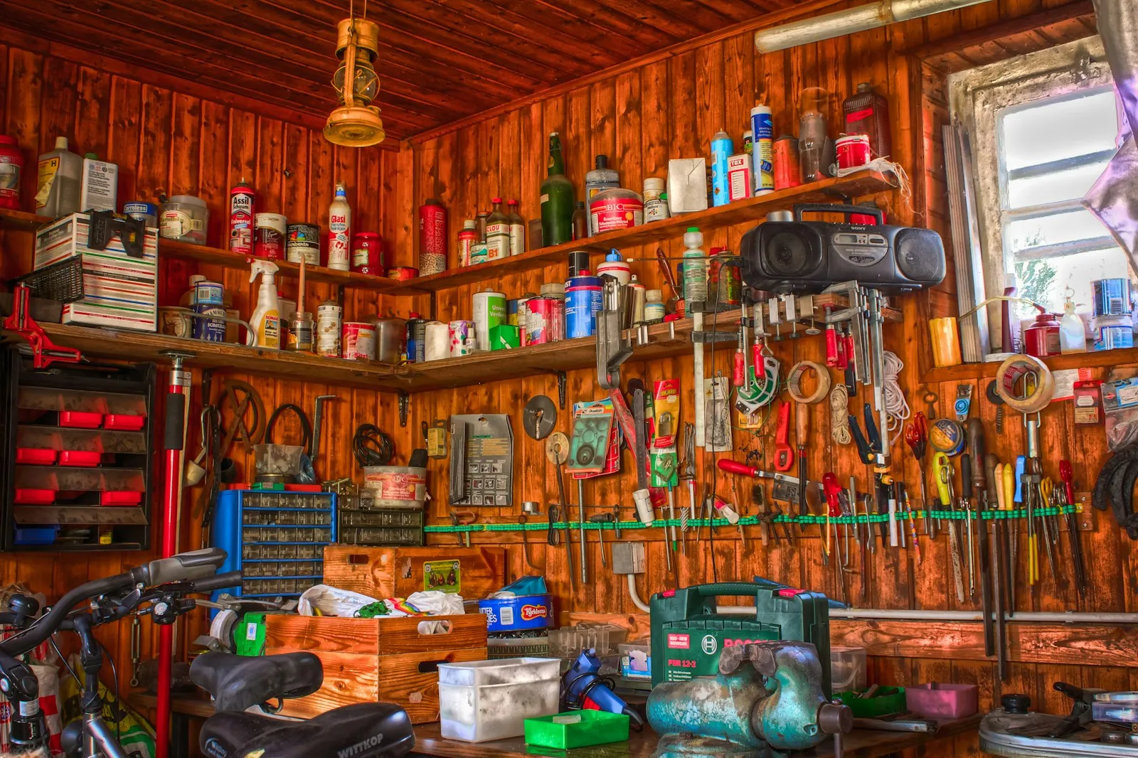 Assorted tools on a wooden shelf — the cordless-tool ecosystem that powers a Milwaukee M18 portable horn build