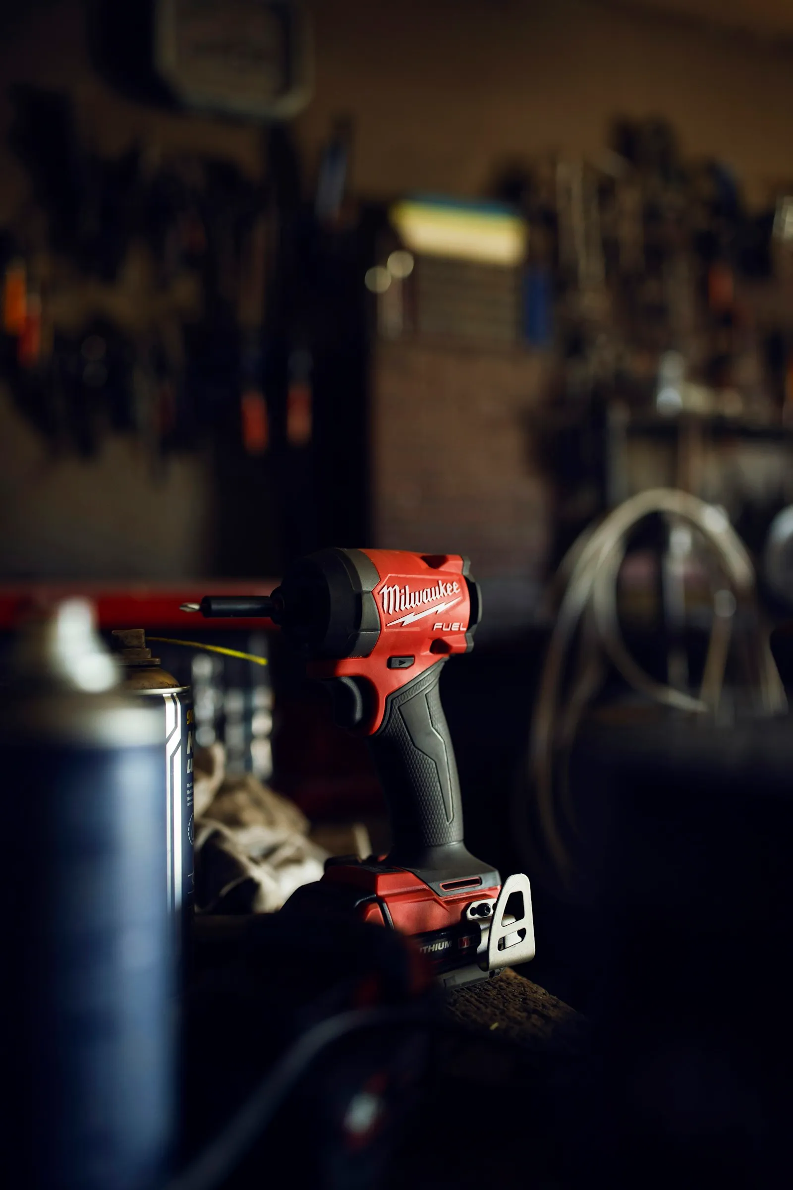 Red impact driver on a workbench — the cordless impact tool that drives the air pump in this DIY build