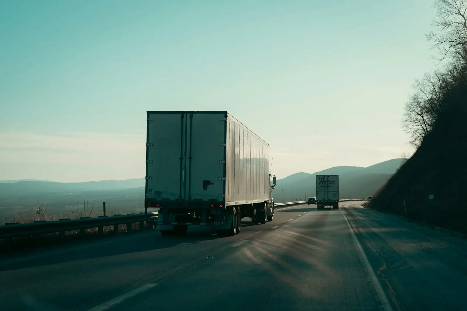 Trucks on a highway road with a mountain view