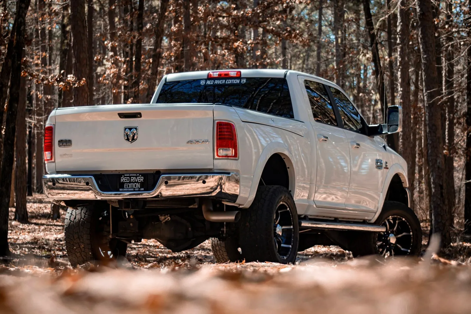 Red Chevy crew cab on dirt road — the truck-modification YouTube culture WhistlinDiesel made famous