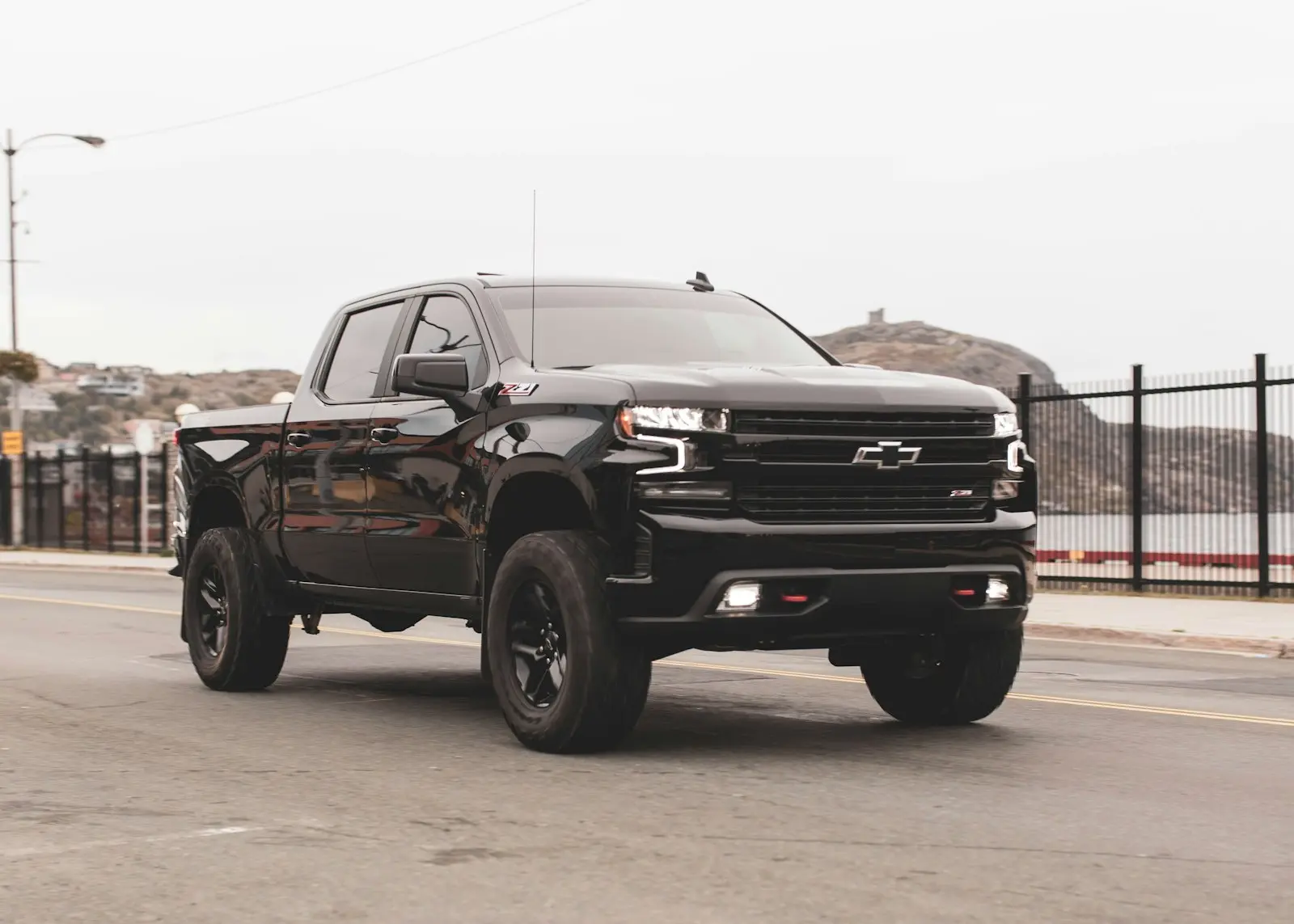 Black Chevy single-cab pickup on gray ground — typical compact-budget install context for the Wolo Dragon Express