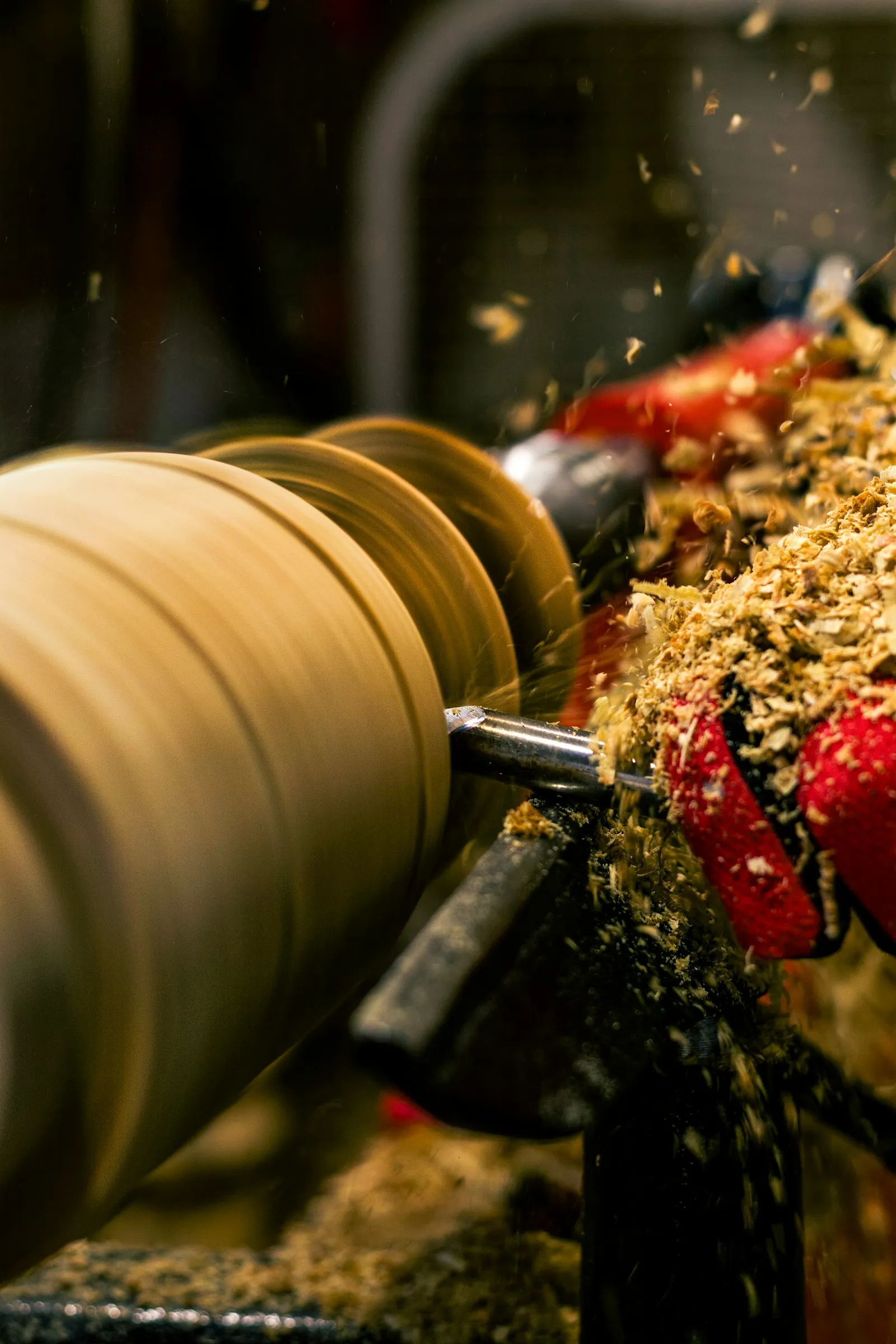 Woodturning lathe with shavings flying — how a hardwood bell is shaped for a craft / display train horn